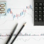 Grafik analisis keuangan dengan kalkulator dan dokumen di meja kerja